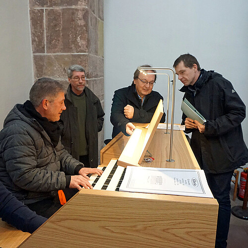 Fünf Personen stehen an der digitalen Orgel in der Klosterkirche Fredelsloh.
