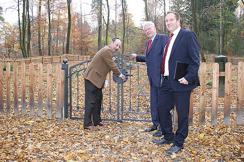 Drei Männer, darunter Klosterkammer-Präsident Hans-Christian Biallas, stehen vor einem Tor.