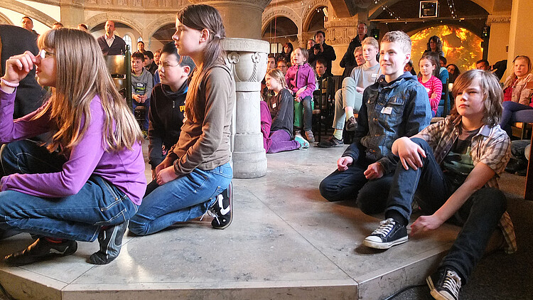 Das von der Klosterkammer geförderte Projekt "Zwischen Himmel und Hölle": Jungen und Mädchen sitzen in einem Kirchenraum.