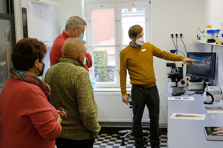 Mitarbeiter der Klosterkammer zeigt auf einen Computerbildschirm im Labor der Klosterkammer