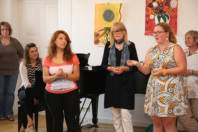 Sechs Frauen stehen vor einem Flügel.