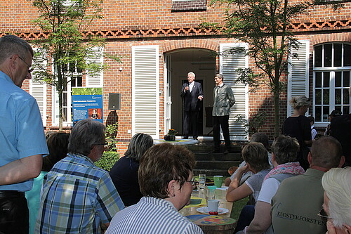 Eine Gruppe von Personen hört Klosterkammer-Präsident Hans-Christian Biallas beim Sommerfest der Klosterforsten zu.