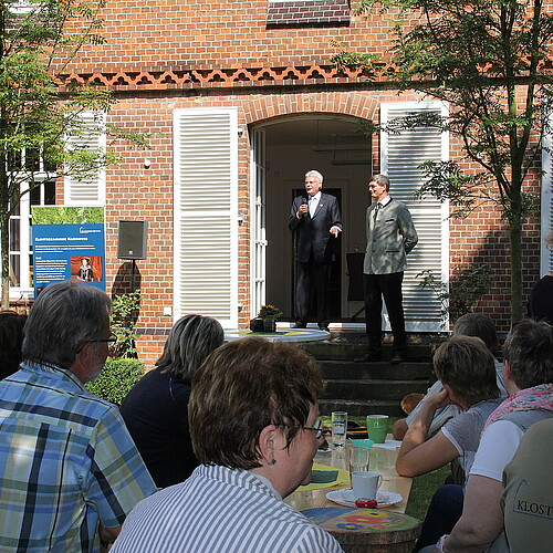 Eine Gruppe von Personen hört Klosterkammer-Präsident Hans-Christian Biallas beim Sommerfest der Klosterforsten zu.
