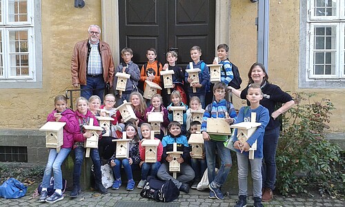 Kinder mit Vogelnistkästen