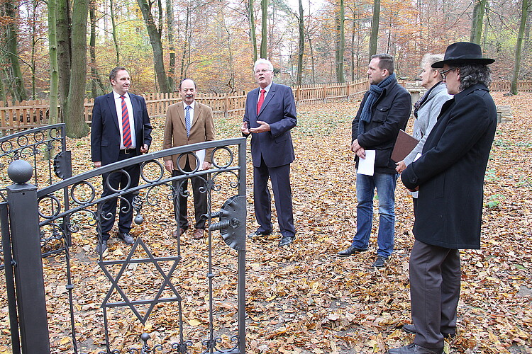 Eine Frau und fünf Männer, darunter Klosterkammer-Präsident Hans-Christian Biallas, stehen auf dem alten jüdischen Friedhof in Barsinghausen.