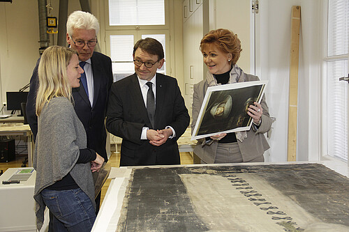 Zwei Frauen und zwei Männer stehen in der Restaurierungswerkstatt der Klosterkammer an einem Tisch.
