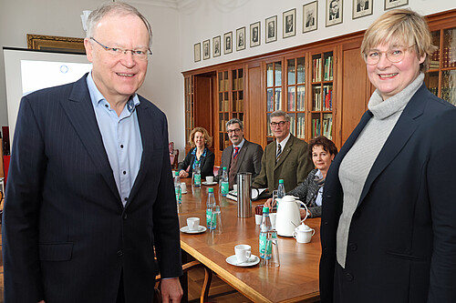 Zwei Personen stehen im Vordergrund, der Ministerpräsident Stephan Weil und die Klosterkammer-Präsidentin Dr. Thela Wernstedt. Im Hintergrund sitzen vier Personen.