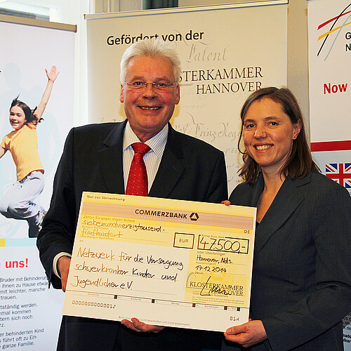 Eine Frau und ein Mann, darunter Klosterkammer-Präsident Hans-Christian Biallas, halten einen Scheck.