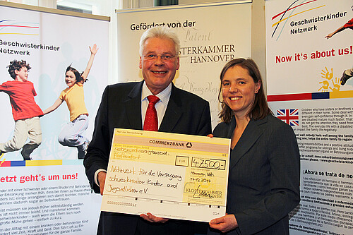 Eine Frau und ein Mann, darunter Klosterkammer-Präsident Hans-Christian Biallas, halten einen Scheck.