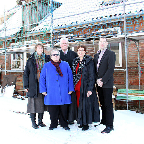 Drei Frauen und zwei Männer, darunter Klosterkammer-Präsident Hans-Christian Biallas, Rosemarie Meding, Äbtissin im Kloster Marienwerder, und Dr. Tim Wameling, Baudezernent der Klosterkammer Hannover, stehen vor einem eingerüsteten Gebäude  des Klosters Marienwerder im Schnee.