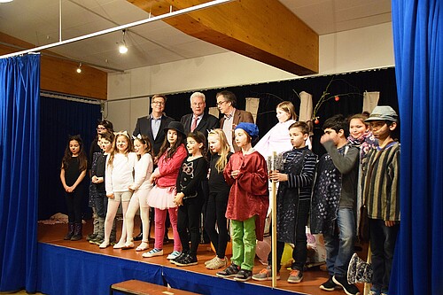 Eine Gruppe von Kindern und drei Männer, darunter Klosterkammer-Präsident Hans-Christian Biallas, stehen auf einer Bühne.