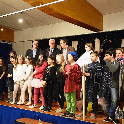 Eine Gruppe von Kindern und drei Männer, darunter Klosterkammer-Präsident Hans-Christian Biallas, stehen auf einer Bühne.