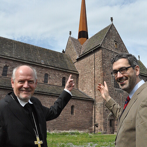 Zwei Männer zeigen auf den neu aufgebauten Vierungsturm des des Klosters Amelungsborn.