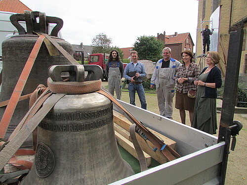 Zwei Frauen und drei Männer, darunter Mathias Riethmüller, Bauleiter der Klosterkammer Hannover, nehmen neue und reparierte Glocken in Empfang.