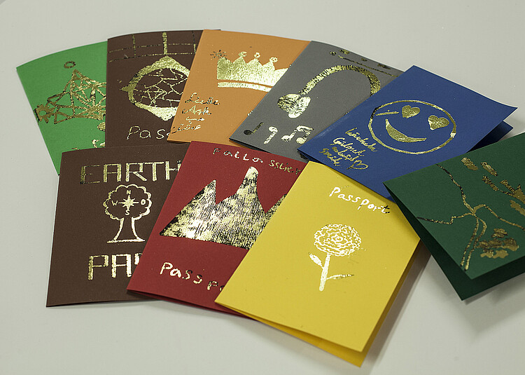 Alternative Wunsch-Reisepässe aus buntem Karton mit unterschiedlichen Aufschriften.