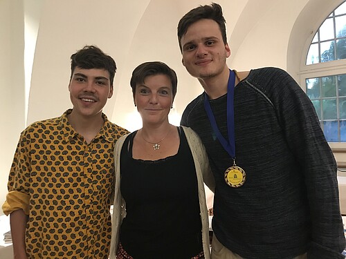 Drei Personen stehen nebeneinander.