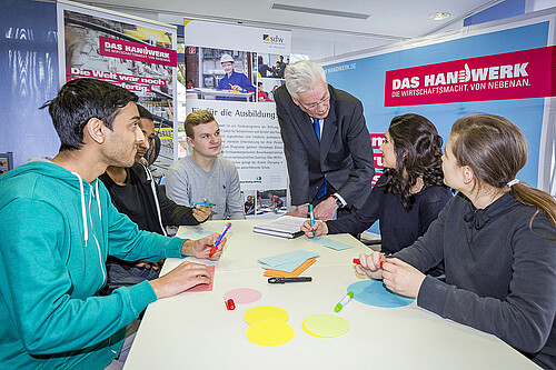 Fünf Jugendliche und Klosterkammer-Präsident Hans-Christian Biallas sind um einen Tisch herum gruppiert.