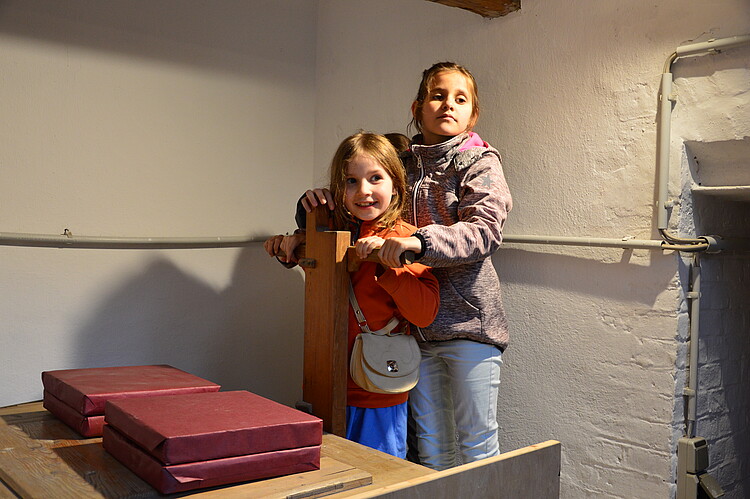 Zwei Kinder bedienen die Balganlage der Orgel.