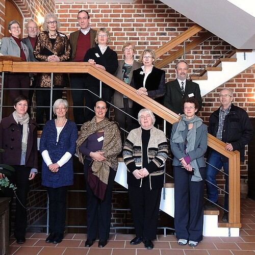 Vierzehn Frauen und Männer, darunter Klosterkammer-Archivar Wolfgang Brandis, stehen in einem Treppenhaus.